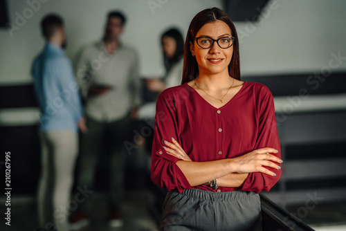 Fotografie Confident business woman standing with team in background