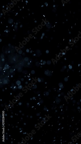 Blue Floating Particles on Dark Background. Soft glowing particles drift through darkness, creating an atmospheric abstract bokeh effect.