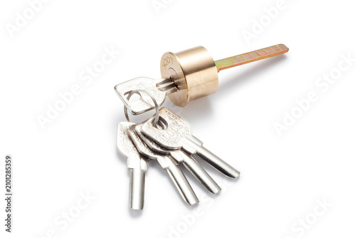 Fotografie A brass cylinder door lock with set of five keys isolated on white background