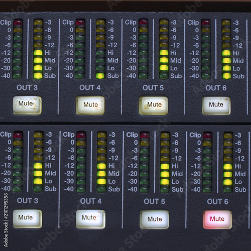 Audio mixing console with illuminated level meters.