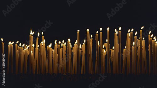 many lit candles against a dark background