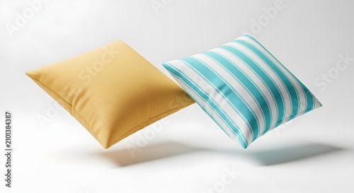 Two decorative pillows, one yellow and one turquoise striped, floating against a white background.