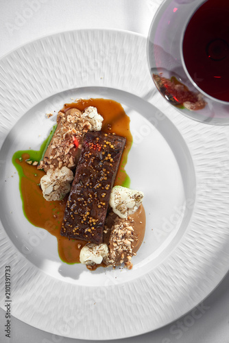 Gourmet roasted meat with mustard seeds, cauliflower, puree, and red wine. Top view elegant minimalist fine dining table setting.