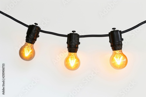 Three glowing vintage edison style light bulbs hanging from a black wire cord creating a warm festive atmosphere for celebratory events on white background