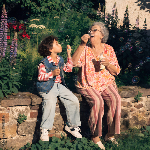 Grandmother and Grandchild Blowing Bubbles Together in a Garden