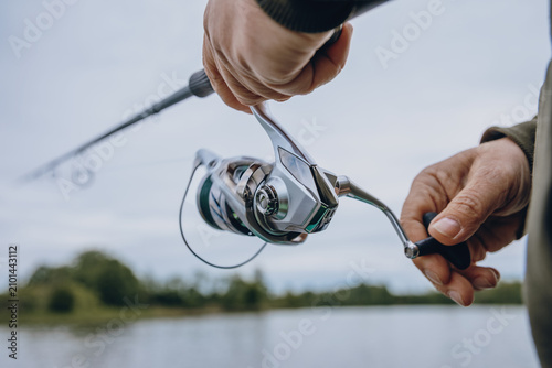 A spinning rod with a spinning reel in the hands of a fisherman