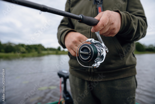 A spinning rod with a spinning reel in the hands of a fisherman