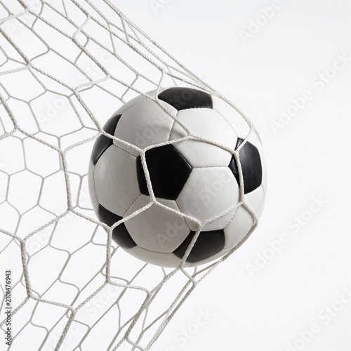 Soccer ball in net scoring a goal, isolated on a clean white background with a close-up view, representing sports success and achievement.