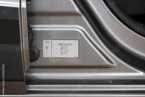 Close up of a VIN and weight label in a new car door gap