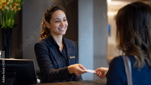 Female Hotel Receptionist Welcoming Guest at Front Desk