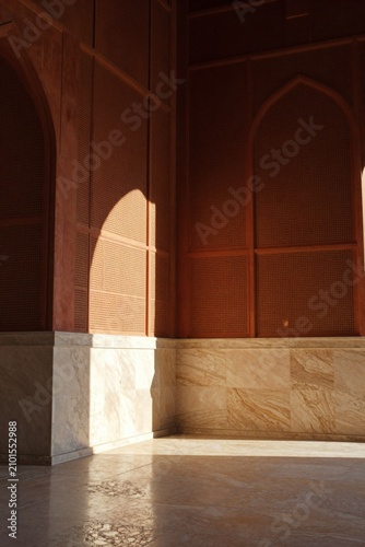 Modern Minimalist Mihrab Interior Terracotta Walls Sunlight Shadows on Marble Floor Background with Copy Space