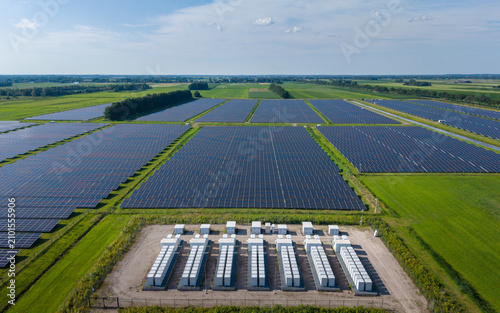 Cuadro en lienzo Aerial view of a large-scale solar farm featuring extensive rows of photovoltaic panels and a battery energy storage system in the rural landscape of Wanneperveen, Overijssel, Netherlands