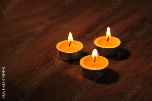 Photos Lit tealight candles on a wooden table creating a warm and peaceful atmosphere f