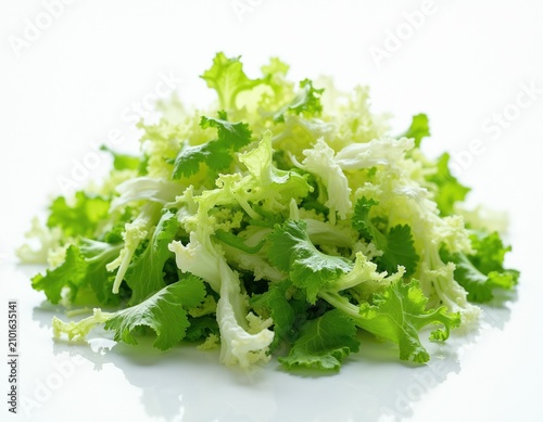 Pile of fresh shredded lettuce mix. Green and white leafy vegetables ready for salad. Healthy food ingredient on white surface. Natural food prep.