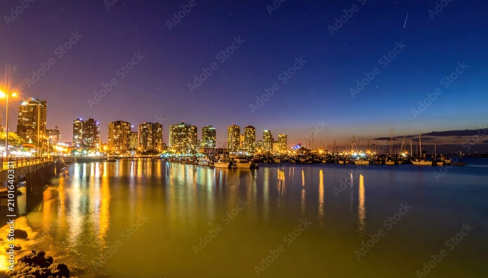 Obraz premium Nighttime Cityscape Reflection - A Stunning View of Urban Lights.