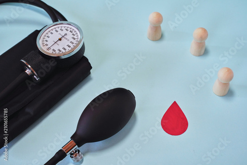 Sphygmomanometer blood pressure monitor with wooden figures and red drop