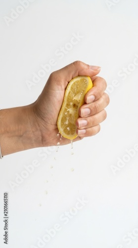 Hand squeezing fresh lemon slice