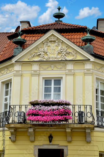 A flower-filled balcony and details of a historic 18th-century building in Warsaw