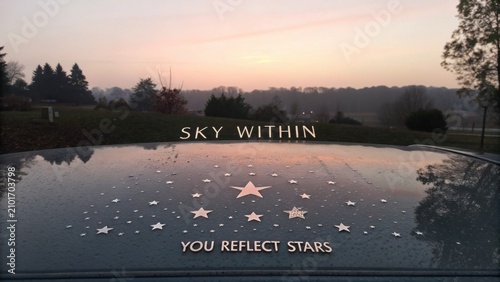 Inspirational Morning Landscape with Reflective Car Roof and Star Design Against Soft Sunrise Colors
