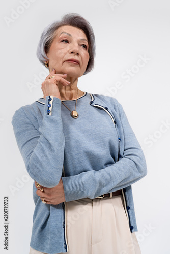 Quadro su tela Stylish senior woman showcases graceful beauty in a modern studio setting