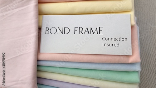 Soft Textiles in Pastel Colors with Bond Frame Sign for Connection Insured Display in Fashion or Home Decor Setting