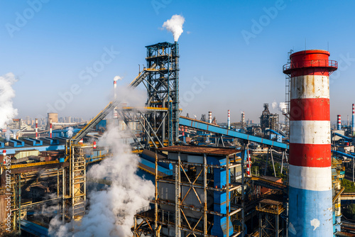 Aerial view of Wuhan steel plant, featuring a complex geometry of massive blast furnaces and intricate pipelines. It reflects China's industry and economy evolution, producing silicon steel for electr