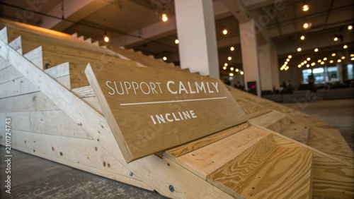 Wooden Incline Structure with Sign Encouraging Calm Support in Modern Workspace Environment