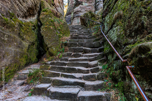 фотографія Ancient stone stairway through mossy rocky passage in nature