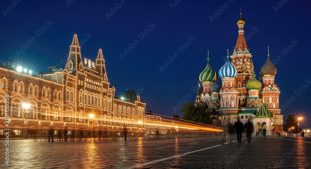 Fototapeta premium Illuminated historic cathedral and building at night in a city square setting