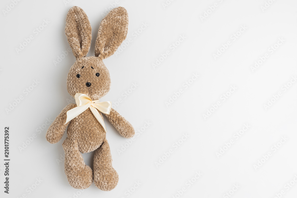 Fototapeta premium Handmade brown crochet plush bunny toy with ribbon