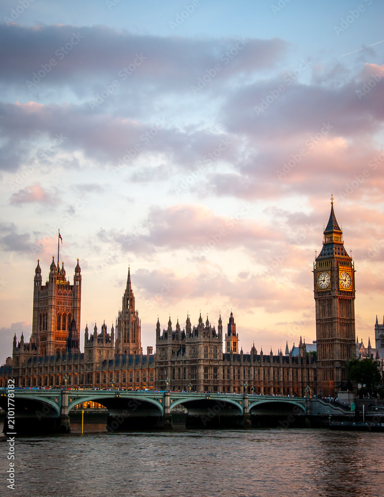Fototapeta premium Houses of Parliament at sunset. Dramatic sky over Big Ben and Westminster Bridge reflected in the River Thames, London.