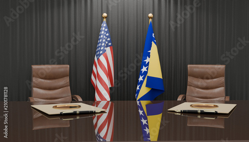 Foto Diplomatic Table: Two chairs flank a polished table, with the flags of the United States and Bosnia and Herzegovina standing side-by-side
