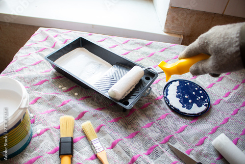 Fotografie Hand dipping roller into paint tray