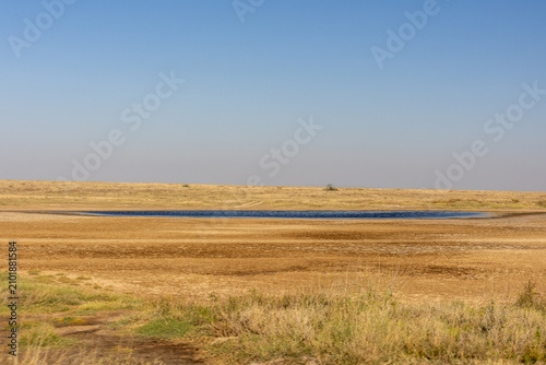 Isolated waterhole in the arid landscape of Serengeti National Park Tanzania