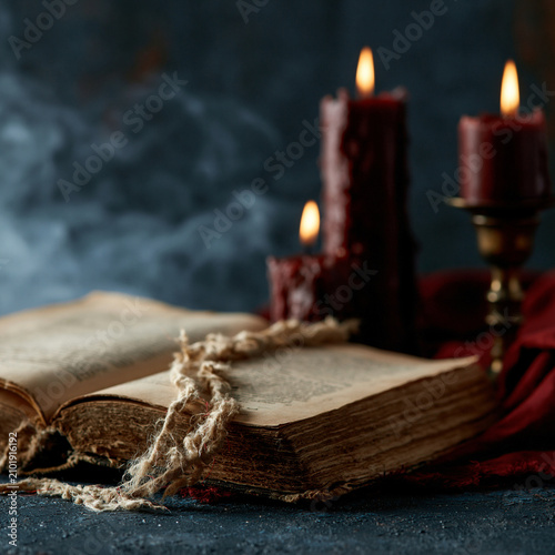 Ancient spell book open with candles
