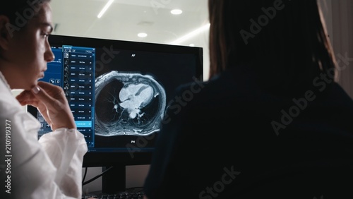 Obraz na plátně Healthcare professionals discussing cardiac MRI examination using a digital radi