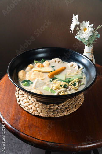 Картината върху платно Hot Pot Delight: A steaming bowl of rich, flavorful hot pot brimming with fresh vegetables, noodles, and assorted ingredients, served on a rustic wooden table