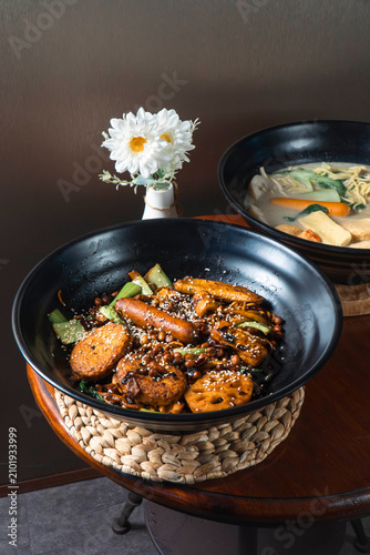 Konstfotografi A Culinary Masterpiece: A rich, flavorful dish served in a black bowl, featuring a unique blend of ingredients and garnishes, hinting at an explosion of taste