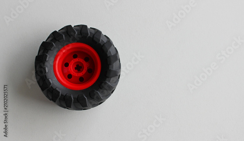A 3D model of an SUV wheel with heavy duty tires lies on a white surface with copy space on the side of image
