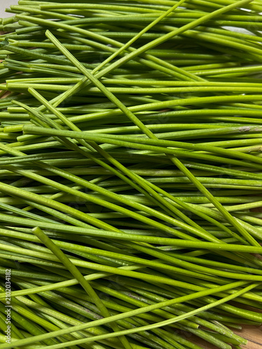Photography Top view abstract background of fresh vibrant green chives or garlic scapes stem