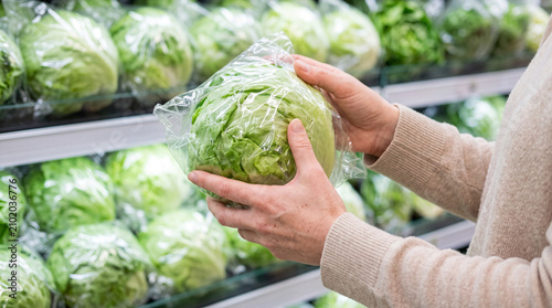 Woman Selecting Fresh Lettuce Amid Cyclosporiasis Outbreak Concerns
