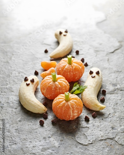 Festive halloween fruit snacks clementine pumpkins and banana ghosts with chocolate chips