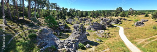 Konstfotografi Luftaufnahme des Felsenmeers im Wental mit markanten Felsformationen aus Jurakalk, umgeben von einem dichten Nadelwald und Wanderwegen auf der Schwäbischen Alb bei Sonnenschein