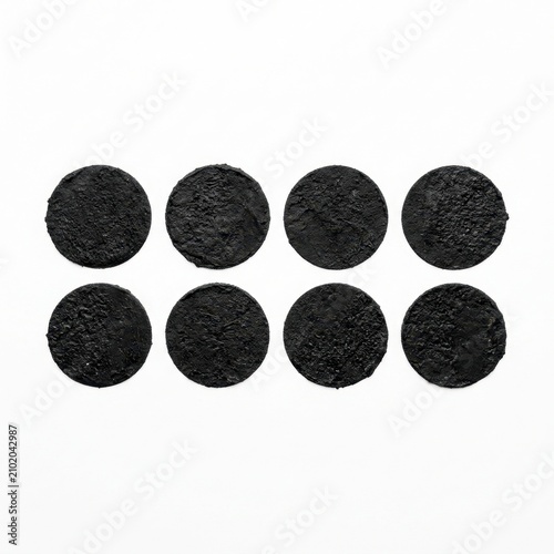 Eight black circles arranged in a clean minimalist composition, solid matte black geometric shapes on a white background