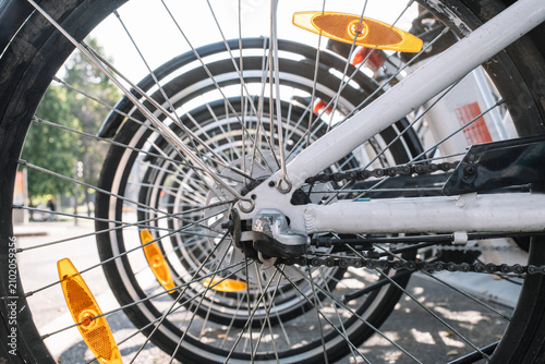 Wheels of contemporary rental bikes parked in row on sunny day in Madrid, Spain