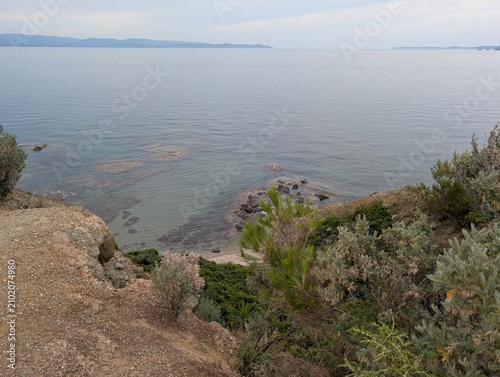 Foto High angle view of a pristine rocky cove with crystal clear shallow waters and green scrubland on the French Mediterranean coast
