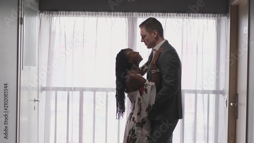 Foto A pair of lovers tenderly and passionately look at each other near a large window