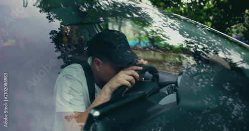 Canvastavla Man gripping steering wheel with clenched jaw, facing forward in silence, portra