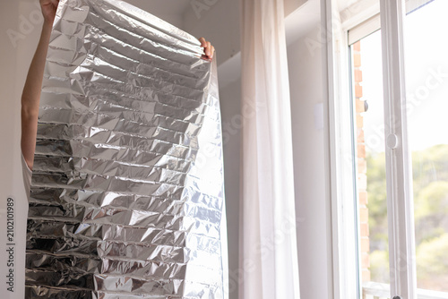 Man holding unrolled sun protection foil film for windows.
