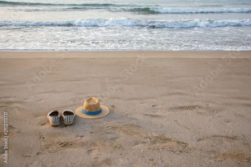 Panama hat and espadrilles on quiet sandy beach